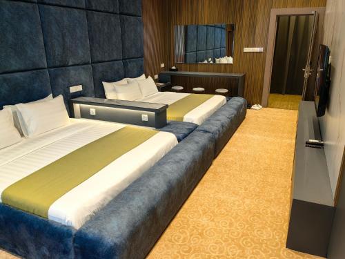 a hotel room with two beds and a television at Hotel Marudu Inn in Pingan Pingan