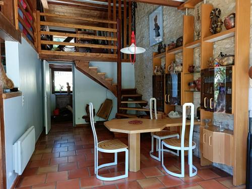 une salle à manger avec une table et un escalier dans l'établissement Belle Demeure Sarladaise, à Sarlat-la-Canéda