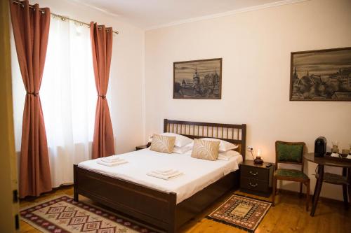 a bedroom with a bed and a desk and a window at Joseph Hayn Apartments in Sighişoara