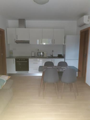 a kitchen with white cabinets and a table and chairs at Alojamento Rodrigues in Arcos de Valdevez