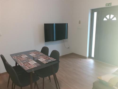 a dining room with a table and chairs and a television at Alojamento Rodrigues in Arcos de Valdevez