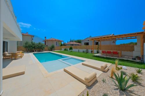 a backyard with a swimming pool and a house at Villa Neo with 2 private pools, bbq, jacuzzi and sauna in Fethiye