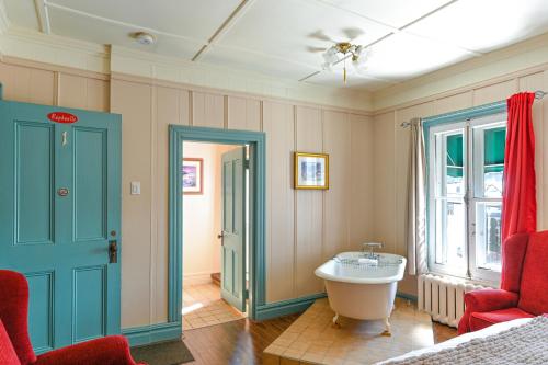 uma casa de banho com uma banheira e um lavatório num quarto em Hôtel-Auberge la Grande Maison et Spa em Baie-Saint-Paul