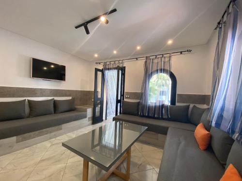 a living room with a couch and a table at Complexe Al AMINE plage -rifiyine in Dar Merah Deriba