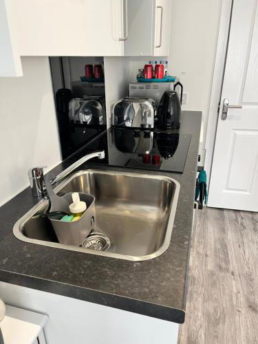 a kitchen counter with a sink and a microwave at Modern Comfy One Bed Apartment - Free Parking in Glasgow