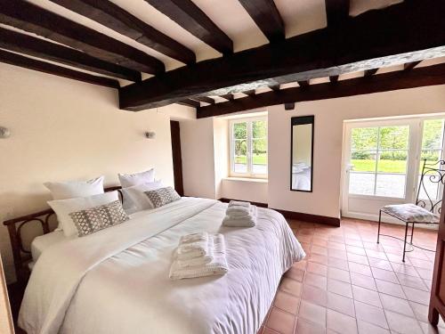 1 dormitorio con 1 cama blanca grande y toallas. en Gîte du Rochelu 4 Étoiles 5000 m2 of Garden, near to Mont Saint Michel & Granville island, en Bourguenolles