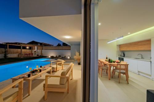 an open kitchen and dining room with a pool in a house at Villa Neo with 2 private pools, bbq, jacuzzi and sauna in Fethiye
