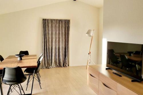 a living room with a desk and a television and a table and chairs at SoloRica House(400m to Lego House,1km to Legoland) in Billund