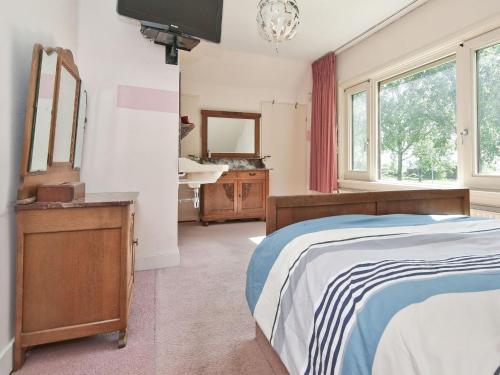 een slaapkamer met een bed, een wastafel en een spiegel bij Characteristic country house with wellness in Lijnden