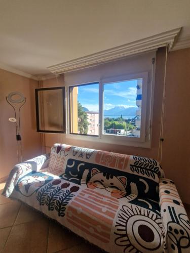 a couch sitting in a living room with a window at Grand appartement 4-8 personnes in Montreux