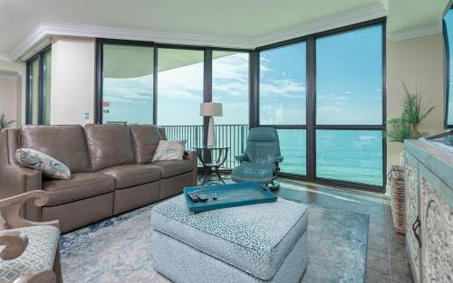 sala de estar con sofá marrón y ventanas de cristal en Phoenix IX 1106 condo, en Orange Beach