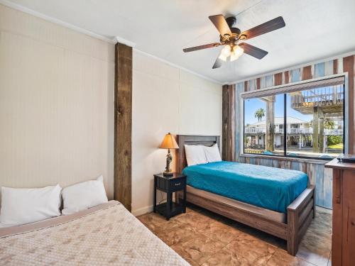 1 dormitorio con 2 camas y ventilador de techo en Tiki Lagoon en Galveston