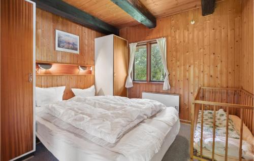 ロモ・キルケビーにあるGorgeous Home In Rm With Saunaの木製の壁に白い大型ベッドが備わるベッドルーム1室