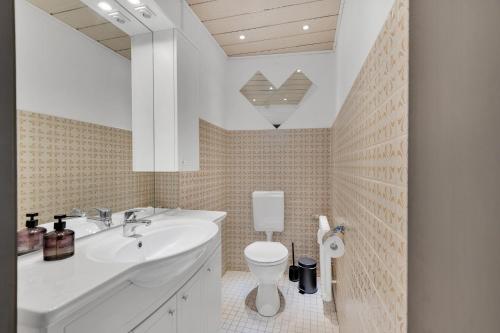 a bathroom with a white sink and a toilet at STANMA Hirschtraum für 7 Personen mit 3 Schlafzimmern in Braunlage