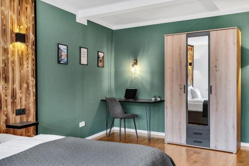 a bedroom with a bed and a desk with a laptop at STANMA Hirschtraum für 7 Personen mit 3 Schlafzimmern in Braunlage