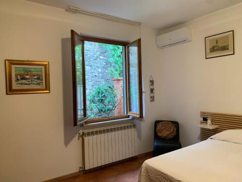 1 dormitorio con cama y ventana en Villino Dragonfly, en Lastra a Signa