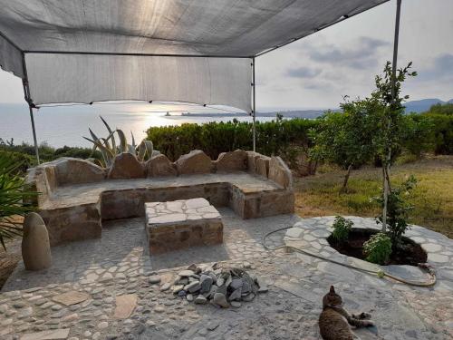 a patio with a bench and an umbrella at Charly Point Villa in Methoni