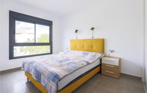 een slaapkamer met een bed met een geel hoofdeinde en een raam bij Nice Apartment In Pilar De La Horadada With Jacuzzi in Pilar de la Horadada