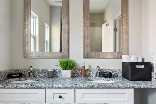 uma casa de banho com dois lavatórios e dois espelhos em Suite Serenity 12Min from Uptown & Spectrum Ctr em Charlotte