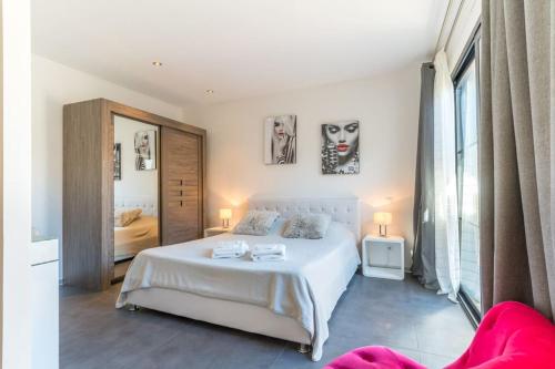 une chambre avec un lit blanc et une grande fenêtre dans l'établissement VILLA AMBIANCE (Pool), à Vieux-Boucau-les-Bains