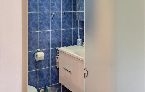 ブランケンベルヘにあるNice Apartment In Blankenberge With Wifiの青いタイルのバスルーム(洗面台、トイレ付)