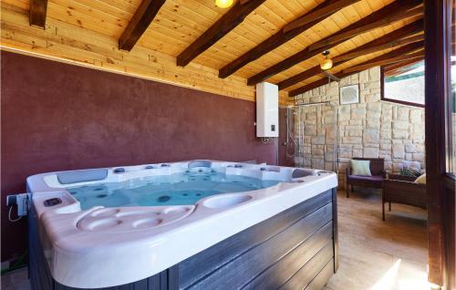 a large bath tub in a room with a wooden ceiling at 2 Bedroom Nice Home In Poljanica Bistranska in Poljanica Bistranska