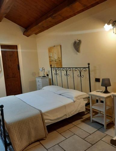a bedroom with a large bed and a table at Il Casale dell'Acquabona in Montefano