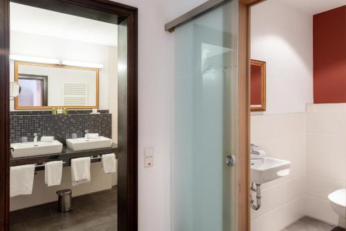ein Badezimmer mit 2 Waschbecken und einem Spiegel in der Unterkunft Eurener Hof in Trier