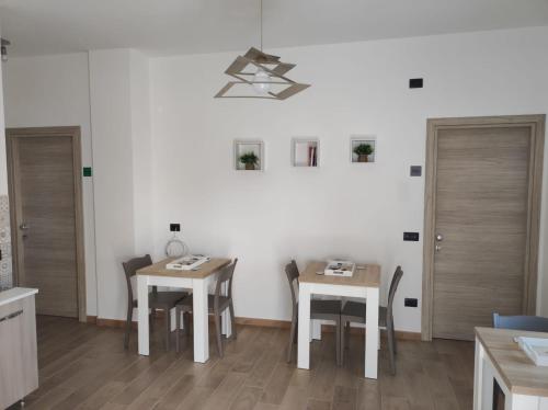 a kitchen with two tables and chairs and a chandelier at Civico 185 in Acri