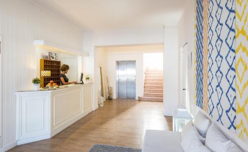 a woman is standing at a counter in a hallway at Hotel Miramar in Port de Soller