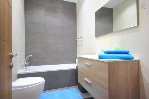 uma casa de banho com um lavatório, um WC e uma banheira em Étoile Court Apt - homey, spacious & private patio em Mġarr