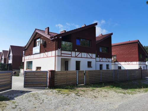 a house with a wooden fence in front of it at Beach Lounge Luxory Apartments in Klaipėda