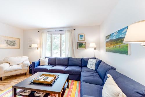 a living room with a blue couch and a table at Fly In Condos Unit E in Waitsfield