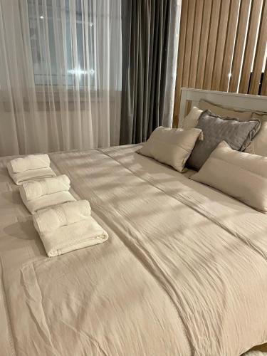 uma cama grande com lençóis brancos e almofadas em Apartament Pastel Room em Leśna
