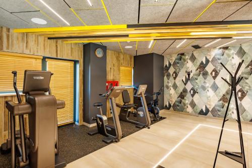 a gym with treadmills and ellipticals in a room at Mava Apartamente in Constanţa