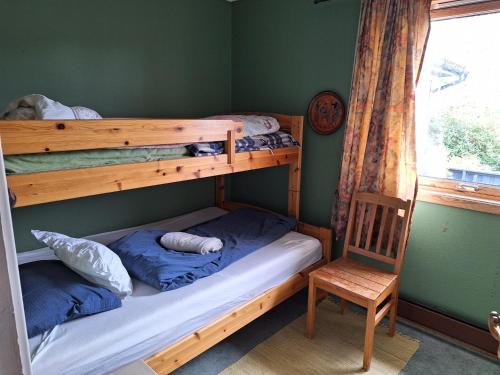 a bedroom with two bunk beds and a chair at Stemmen 16 in Bryne