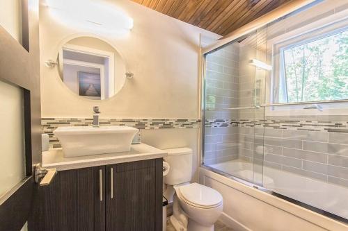 een badkamer met een toilet, een wastafel en een douche bij Nordika Lac St Pierre No. PERMIS CITQ: 298304 in Val des Monts