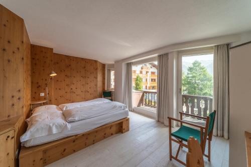 a bedroom with a bed and a large window at Chesa Saluver - Celerina in Celerina