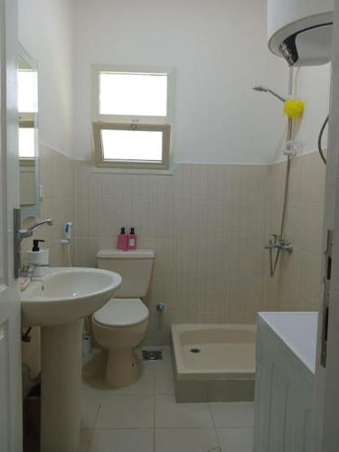 a bathroom with a toilet and a sink and a tub at Luxury King Bed with garden-Zayed Families only in Sheikh Zayed