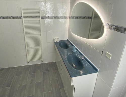 Baño con 2 lavabos y espejo en Le Manoir aux Volets Verts, en Salerm
