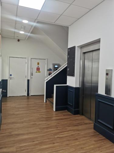 an empty room with a staircase and a hallway at Regent Penthouse in Harrogate