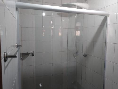 een douche met een glazen deur in de badkamer bij Casinha Sossego na Praia in Caraguatatuba