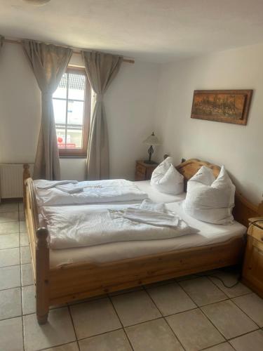 Schlafzimmer mit einem Bett mit weißer Bettwäsche und Kissen in der Unterkunft Gasthof zur Post in Siegen