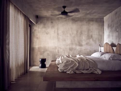a bedroom with a bed with a blanket on it at Acro Suites - A Wellbeing Resort in Agia Pelagia