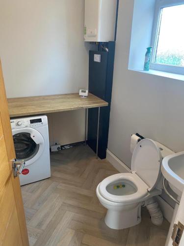 a bathroom with a toilet and a washing machine at Huddersfield 2 bedroom house in Huddersfield