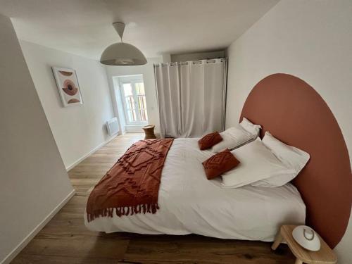 une chambre avec un grand lit avec des oreillers dans l'établissement Maison cosy 4 Personnes, à Tinténiac