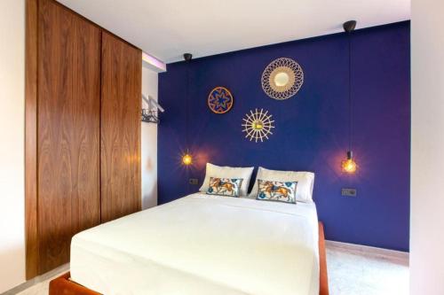 1 dormitorio con 1 cama grande y pared morada en Luxury apartment in center Of Marrakech City, en Marrakech