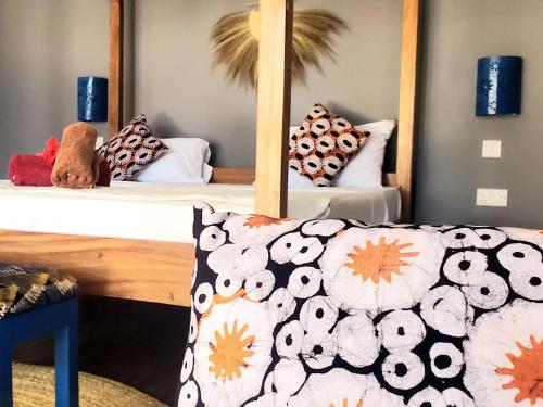 a bedroom with two beds and a couch with pillows at Promised Land Lodge in Kizimkazi