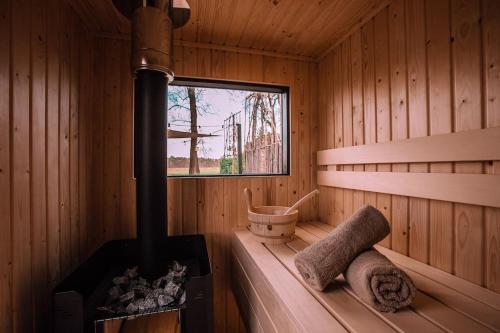 a sauna with a stove and a window in it at Bed & outdoor wellness - natuurhuisje Oisterwijk in Oisterwijk
