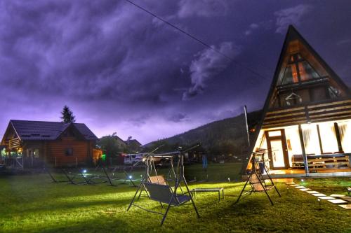 a group of chairs in front of a church at night at A Frame Alpin in Vatra Dornei